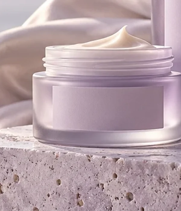 Pote conceitual de creme lilás sobre pedra